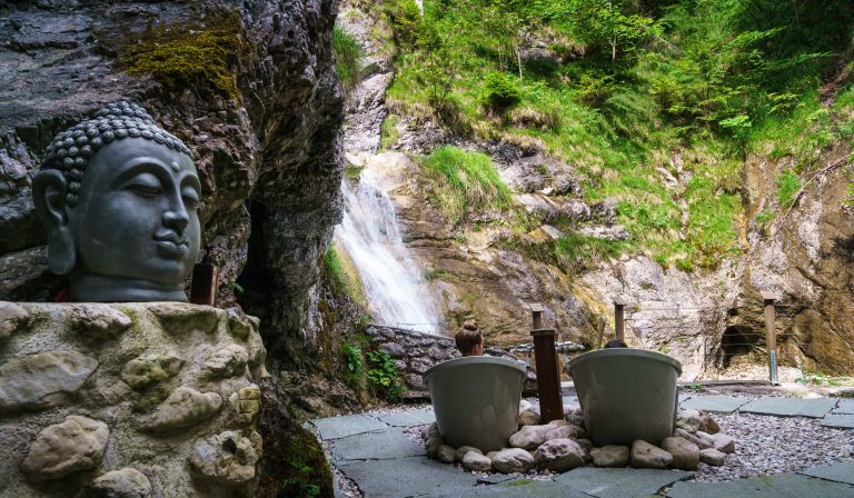 Die unverkennbaren Outdoor-Wannen des Dorfbad Tannermühl mit Blick zum Wasserfall