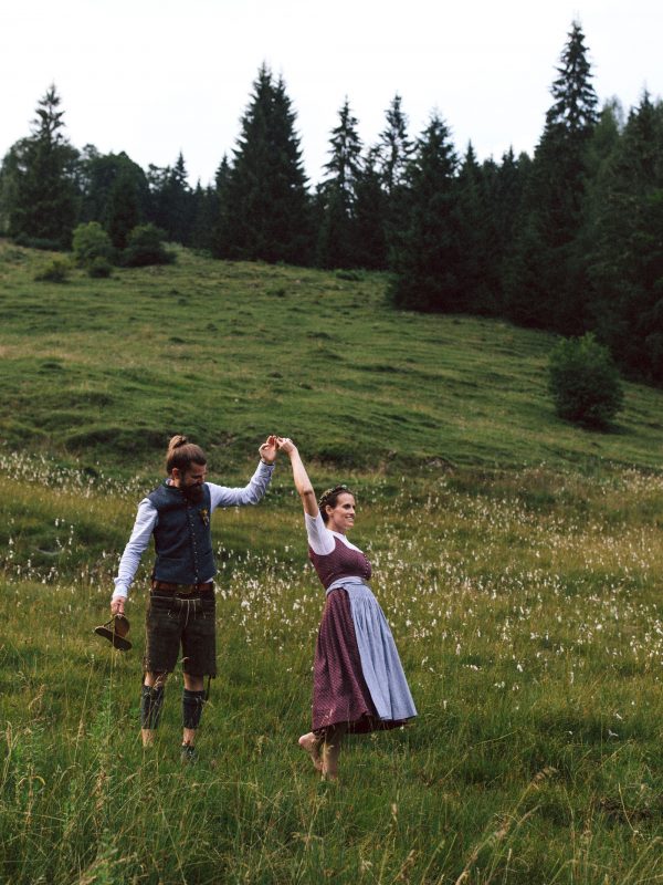 Tanzendes Brautpaar in bayerischer Tracht auf der Almwiese des Almbad Sillberghaus