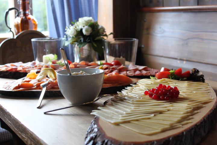 mit Käse, Fisch und Obst gedeckter Frühstücks-Tisch im Almbad Sillberghaus